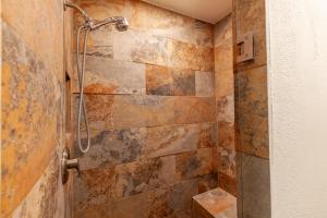 y baño con ducha en una pared de piedra. en Dreamcatcher B&B, en Taos