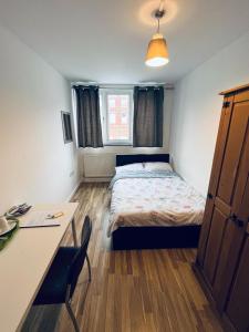 Habitación pequeña con cama, escritorio y escritorio. en Jey's Flat, en Liverpool