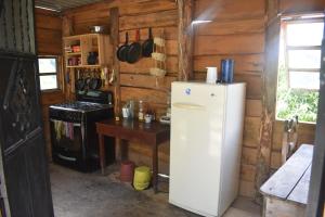 eine Küche mit einem Kühlschrank und einem Tisch in einer Hütte in der Unterkunft Hotel Villa Tzankujil in San Marcos La Laguna