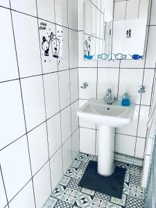 Baño blanco con lavabo y espejo en Jey's Flat en Liverpool