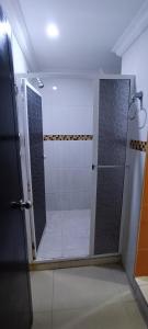 La salle de bains est pourvue d'une douche avec une porte en verre. dans l'établissement Apto los Almendros, à Carthagène des Indes