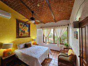 a bedroom with a bed and a brick ceiling at Villa Corona del Mar in Rincon de Guayabitos