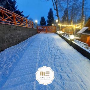 a driveway covered in snow at night with lights at Amutuy Bariloche in San Carlos de Bariloche