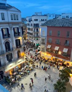 un grupo de personas caminando por una plaza en una ciudad en Emilysuites - Malaga Centro Historico, en Málaga