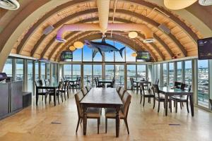 een restaurant met tafels en stoelen en een grote kamer met ramen bij Seas The Day! Complete Panoramic Water Views in Miami