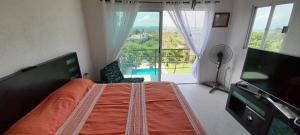 a bedroom with a large bed and a large window at Casa con alberca privada y agradable jardín in Oaxtepec