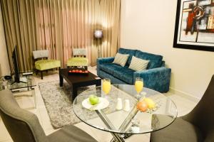a living room with a glass table and a blue couch at Vredenburg Boutique Lodge in Vredenburg