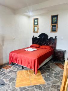 a bedroom with a large bed with a red blanket at Hotel Villa Tzankujil in San Marcos La Laguna