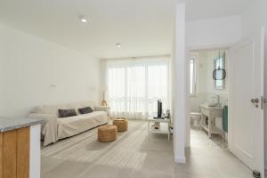 Casa do Ser في فوزيتا: غرفة معيشة بيضاء مع أريكة وطاولة