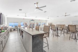 a kitchen with a bar with chairs and tables at Mermaid's Retreat in Marathon