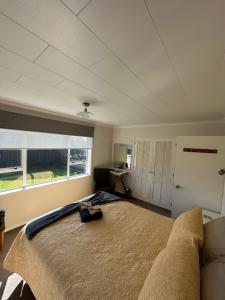 een slaapkamer met een groot bed en een raam bij Glamis Ave Shared Home B&B in New Plymouth