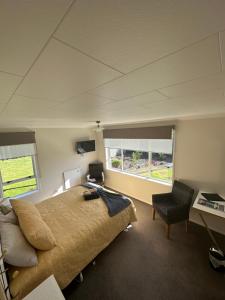 Schlafzimmer mit einem Bett, einem Schreibtisch und einem Fenster in der Unterkunft Glamis Ave Shared Home B&B in New Plymouth