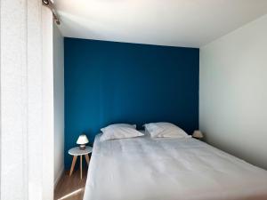 um quarto com uma cama grande e uma parede azul em Gîte Loye-sur-Arnon, 6 pièces, 15 personnes - FR-1-586-36 