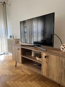 TV de pantalla plana grande en un centro de entretenimiento de madera en Departamento centrico excelente ubicacion Bahia Blanca, en Bahía Blanca