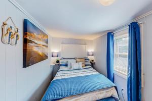 a bedroom with a bed with blue curtains and a window at Montego Bay - Ocean 13336 in Ocean City +42 photos