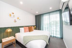 een slaapkamer met een bed en een groot raam bij Grow at Goodwood in Adelaide