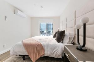 a white bedroom with a large bed and a window at Unbeatable 3BR with Private Patio in Upper East Side in New York