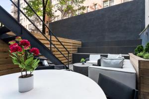 un patio con tavolo bianco, sedie e scale di Unbeatable 3BR with Private Patio in Upper East Side a New York