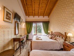 a bedroom with two beds and a desk and a window at Hosteria El Condado by Nordic in San Carlos de Bariloche