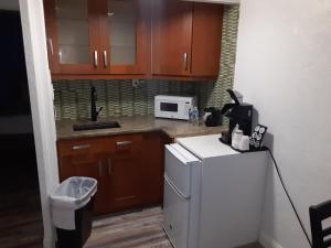 a kitchen with wooden cabinets and a white refrigerator at Sandalwood Beach Resort in St Pete Beach