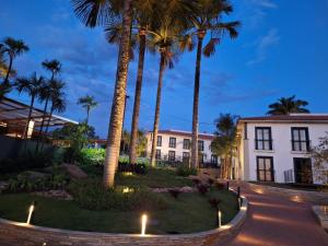 a courtyard with palm trees and a building at Quinta de Santa Barbara Eco Resort in Pirenópolis