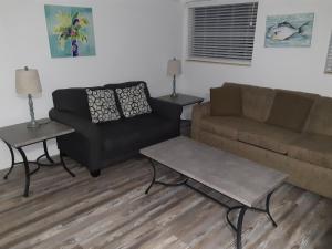 ein Wohnzimmer mit einem Sofa und einem Stuhl in der Unterkunft Sandalwood Beach Resort in St Pete Beach