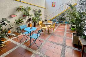 un patio con mesas, sillas y macetas en Casa Azul Boutique Hostel, en Pereira