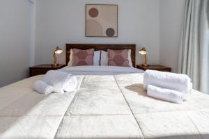 a bedroom with a large white bed with towels on it at Vibrant Inner City Escape Near New Regent Street in Christchurch