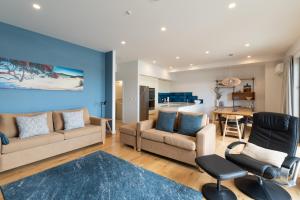 a living room with a couch and chairs and a table at Bay of Islands Apartment with Marina Views in Opua