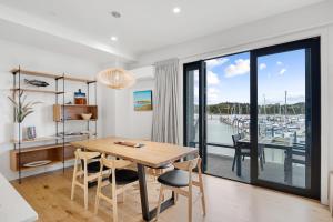 a dining room with a table and a view of a marina at Bay of Islands Apartment with Marina Views in Opua