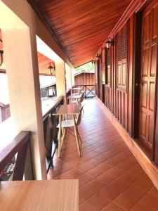 a balcony of a house with a table and benches at Dear Villa House in Luang Prabang