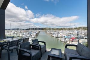 - une vue sur le port de plaisance avec des chaises et des bateaux dans l'établissement Bay of Islands Apartment with Marina Views, à Opua