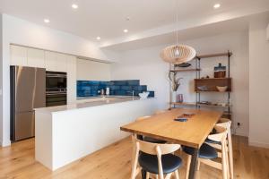 een keuken met een houten tafel en een aantal stoelen bij Bay of Islands Apartment with Marina Views in Opua