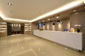 a large lobby with a white counter in a room at Toongmao Hotel Kaohsiung in Kaohsiung