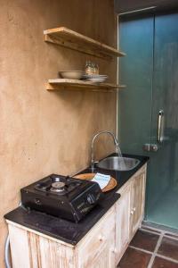 a kitchen with a stove and a sink on a counter at Aryasa Villa 1BR Private Pool Villa Ubud in Ubud