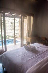 a bedroom with a bed and a large window at Aryasa Villa 1BR Private Pool Villa Ubud in Ubud
