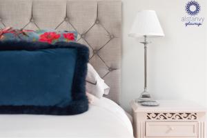 um quarto com uma cama com uma almofada azul e um candeeiro em The Old Office em Royal Tunbridge Wells