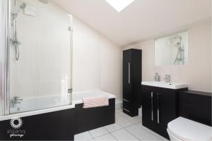 ein Badezimmer mit einer Badewanne, einem WC und einem Waschbecken in der Unterkunft The Old Office in Royal Tunbridge Wells