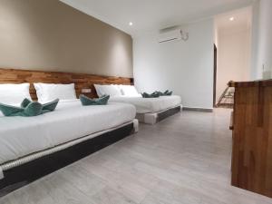 a bedroom with two beds and a wooden wall at Hemingway Cottage 海明威度假屋 in Semporna