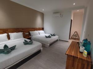 a hotel room with two beds and a table at Hemingway Cottage 海明威度假屋 in Semporna