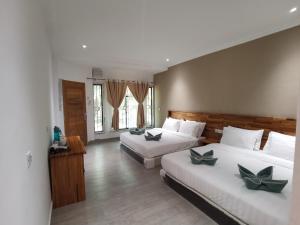 a hotel room with two beds at Hemingway Cottage 海明威度假屋 in Semporna