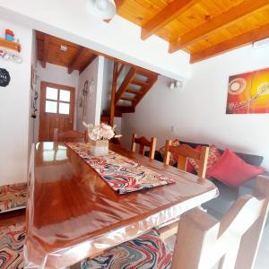uma sala de jantar com uma mesa de madeira e cadeiras em Amutuy Bariloche em San Carlos de Bariloche