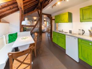 uma cozinha com armários verdes e uma mesa branca em Stunning home for 5 adults with indoor pool em Esneux