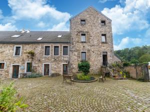 a large stone building with a courtyard in front of it at Stunning home for 5 adults with indoor pool in Esneux