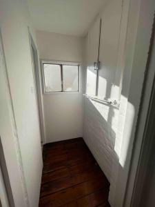 a hallway with a window and a white wall at Victorian Dream Terrace CBD in Sydney