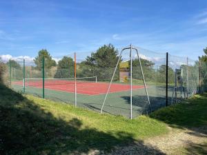 una cancha de tenis con una red en una cancha de tenis en Holiday Home in Carteret near Dunes & Beach, en Barneville-Carteret