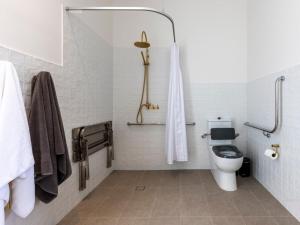 a white bathroom with a toilet and a shower at Benbullen Pavilions in Angaston