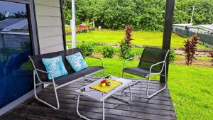 2 Stühle und ein Tisch auf einer Veranda in der Unterkunft TAHITI ITI - Bungalow O Spot Teahupoo in Teahupoo