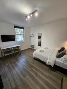 a bedroom with a bed and a desk and a tv at Studio in central London in London