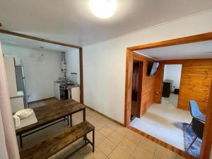 プコンにあるCabaña en Boscoso Lodgeのリビングルーム(木製テーブル付)、キッチン